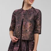 Woman wearing a patterned outfit on a plain background