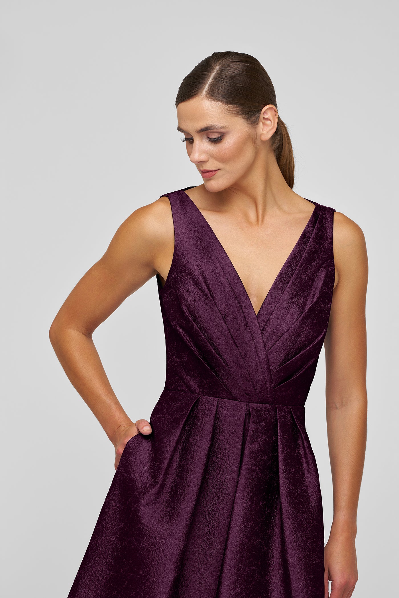Woman wearing a purple dress against a gray background