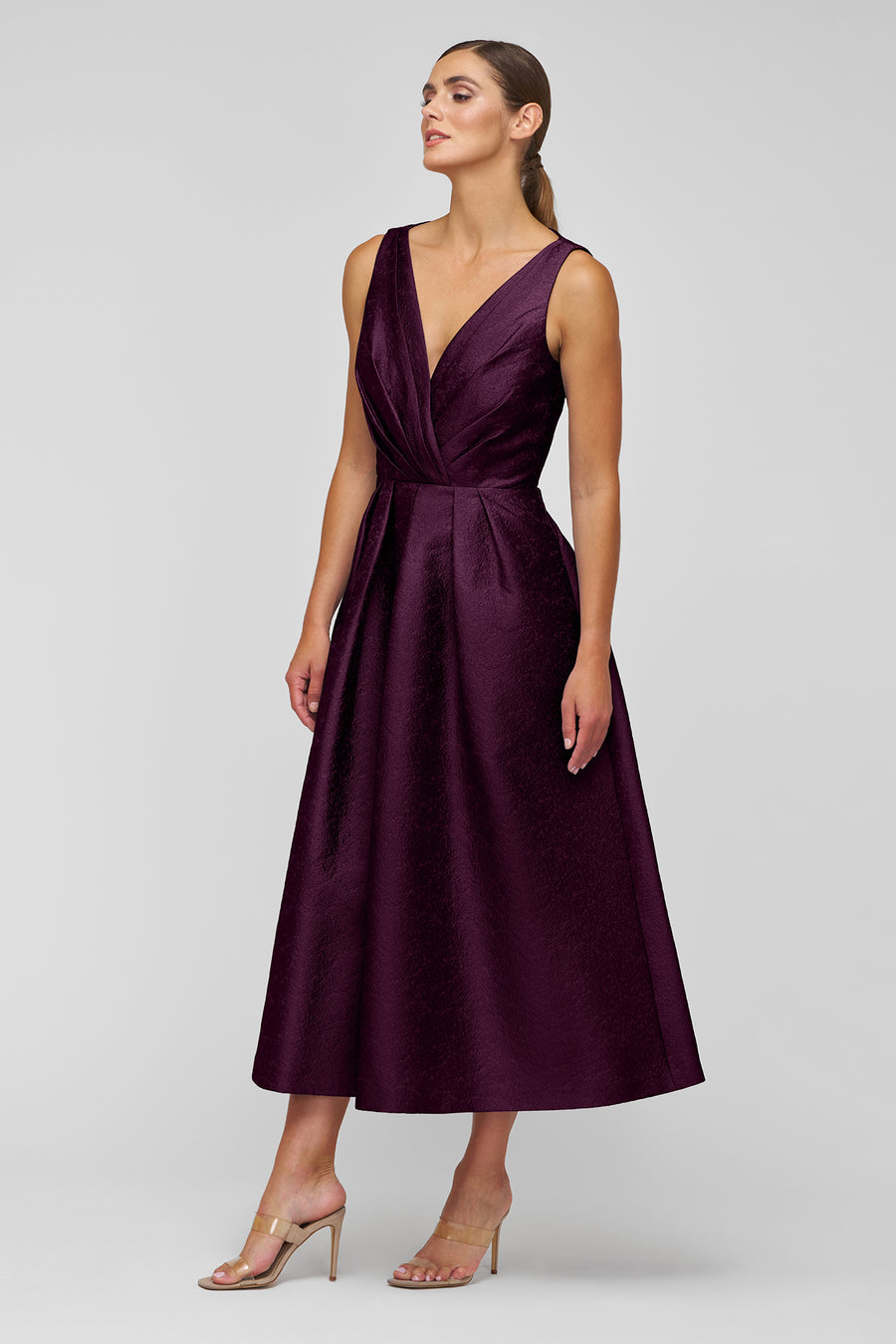 Woman wearing a purple dress against a gray background