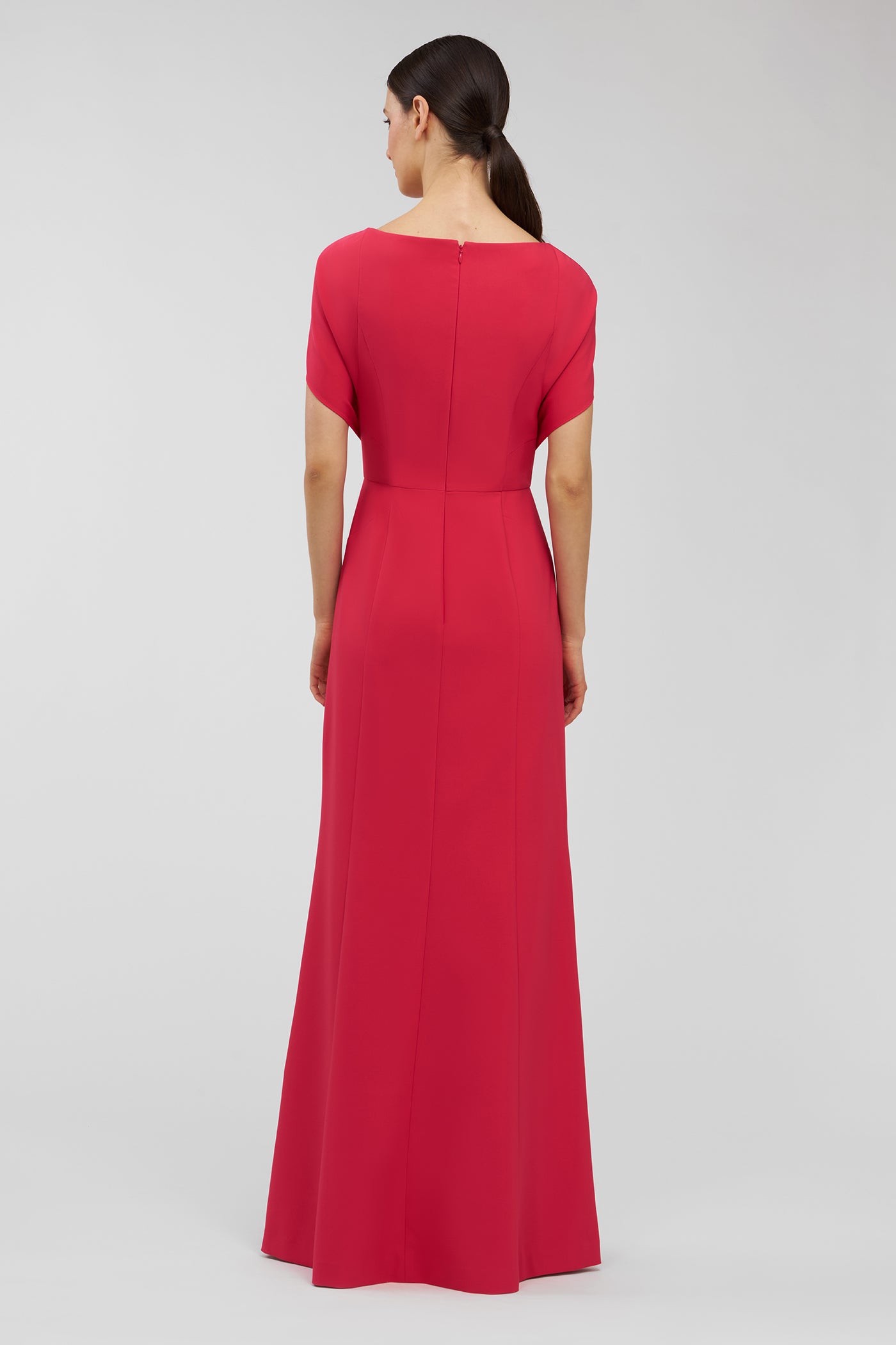 Woman wearing a pink dress on a light gray background