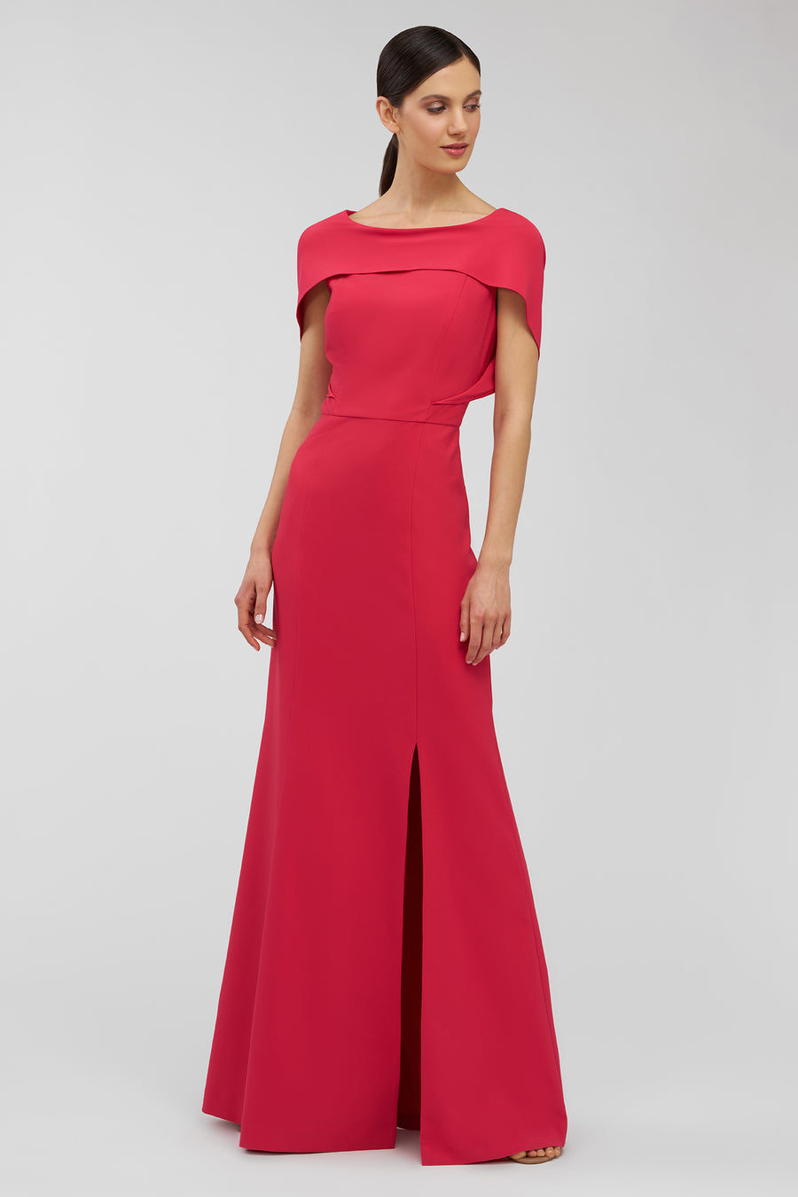 Woman wearing a red evening gown with a slit on a white background