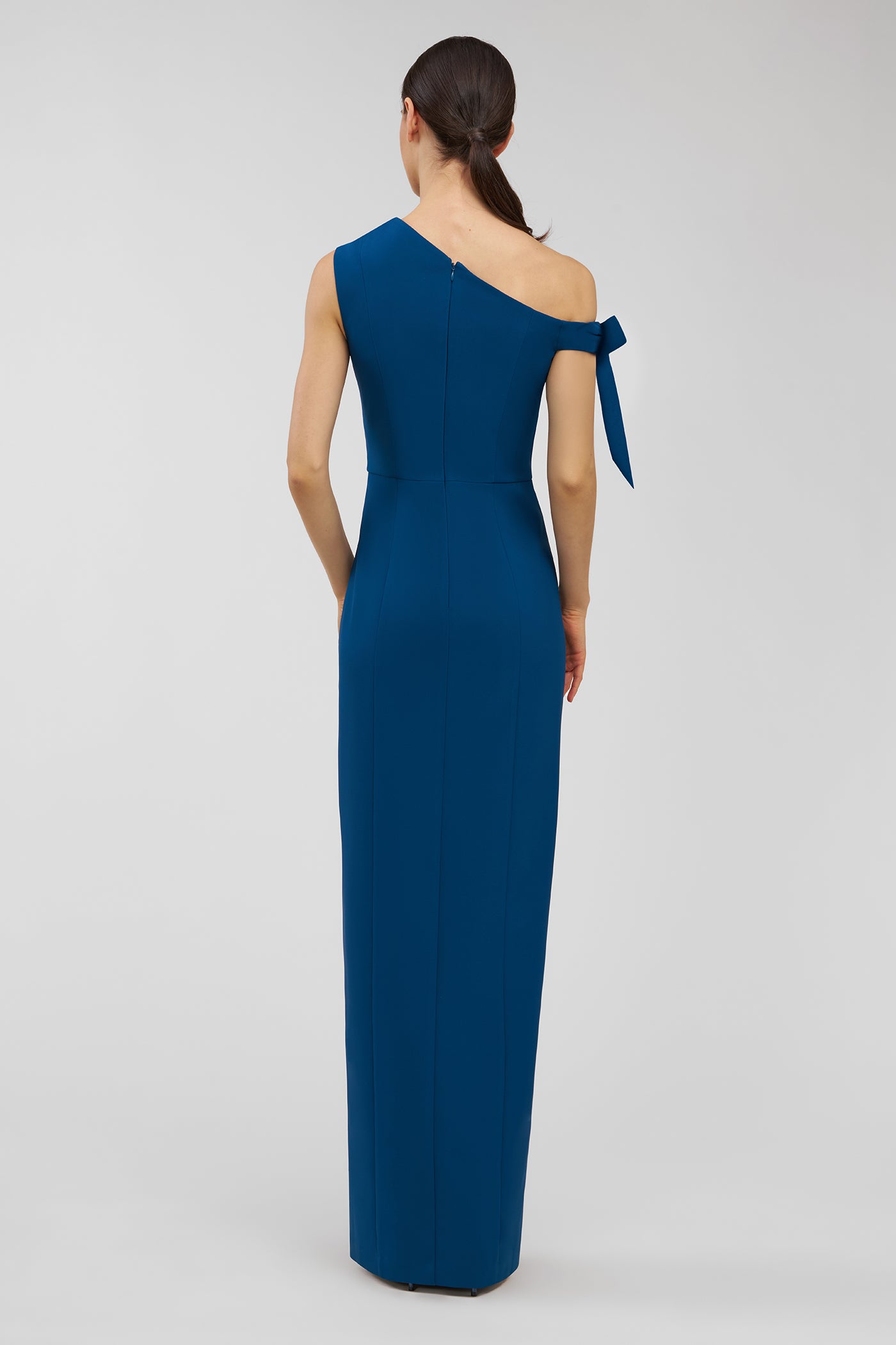 Blue one-shoulder dress with a bow detail on a white background