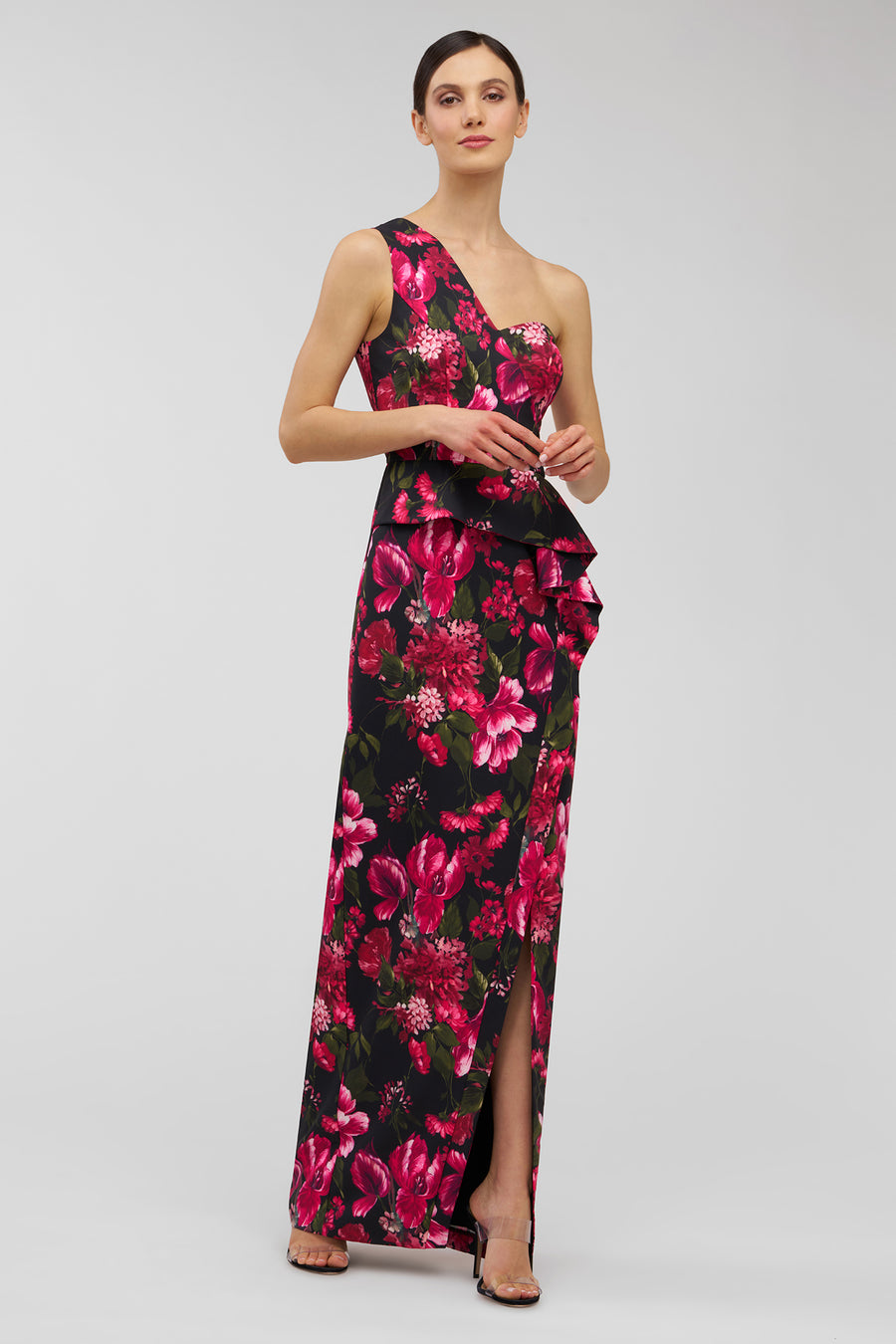 Woman wearing a floral evening gown on a light gray background