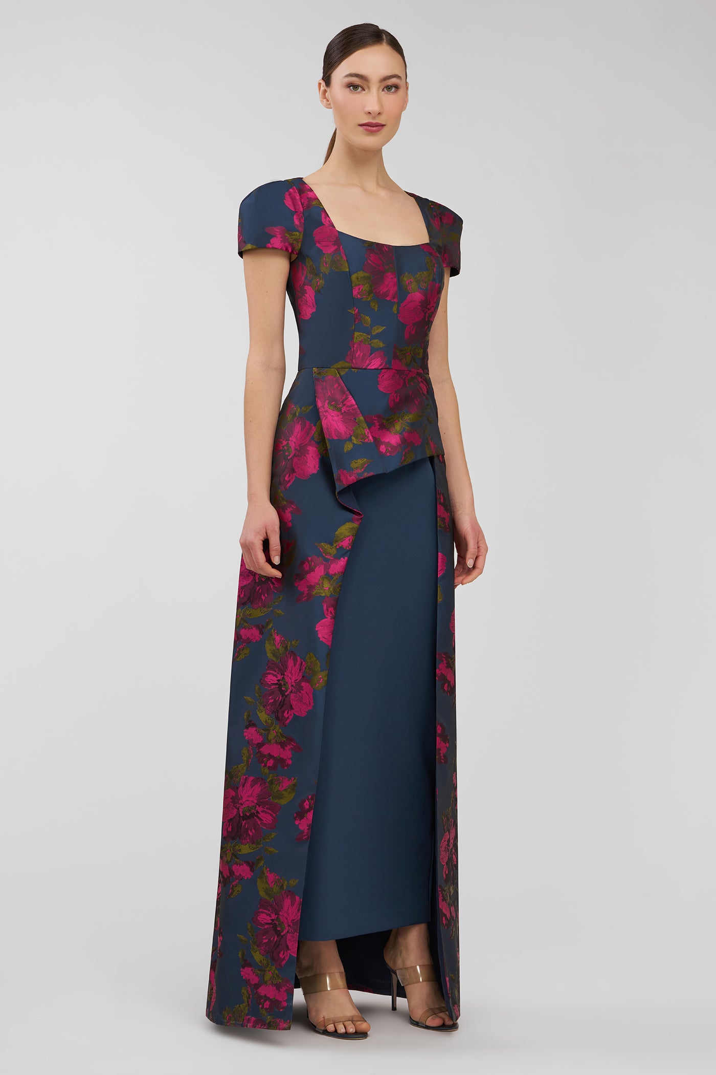 Woman wearing a floral dress with a layered design on a gray background