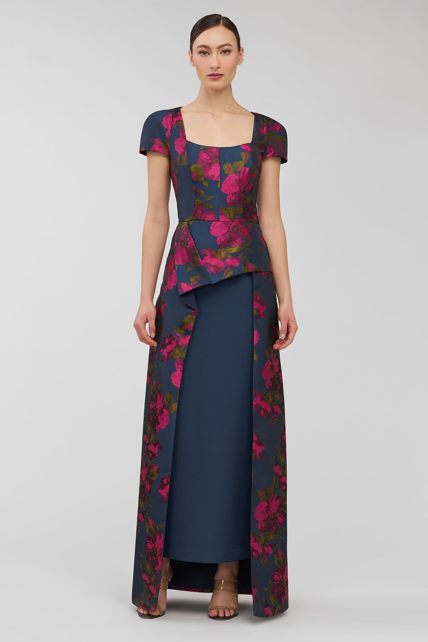 Woman wearing a floral dress with a blue base on a gray background