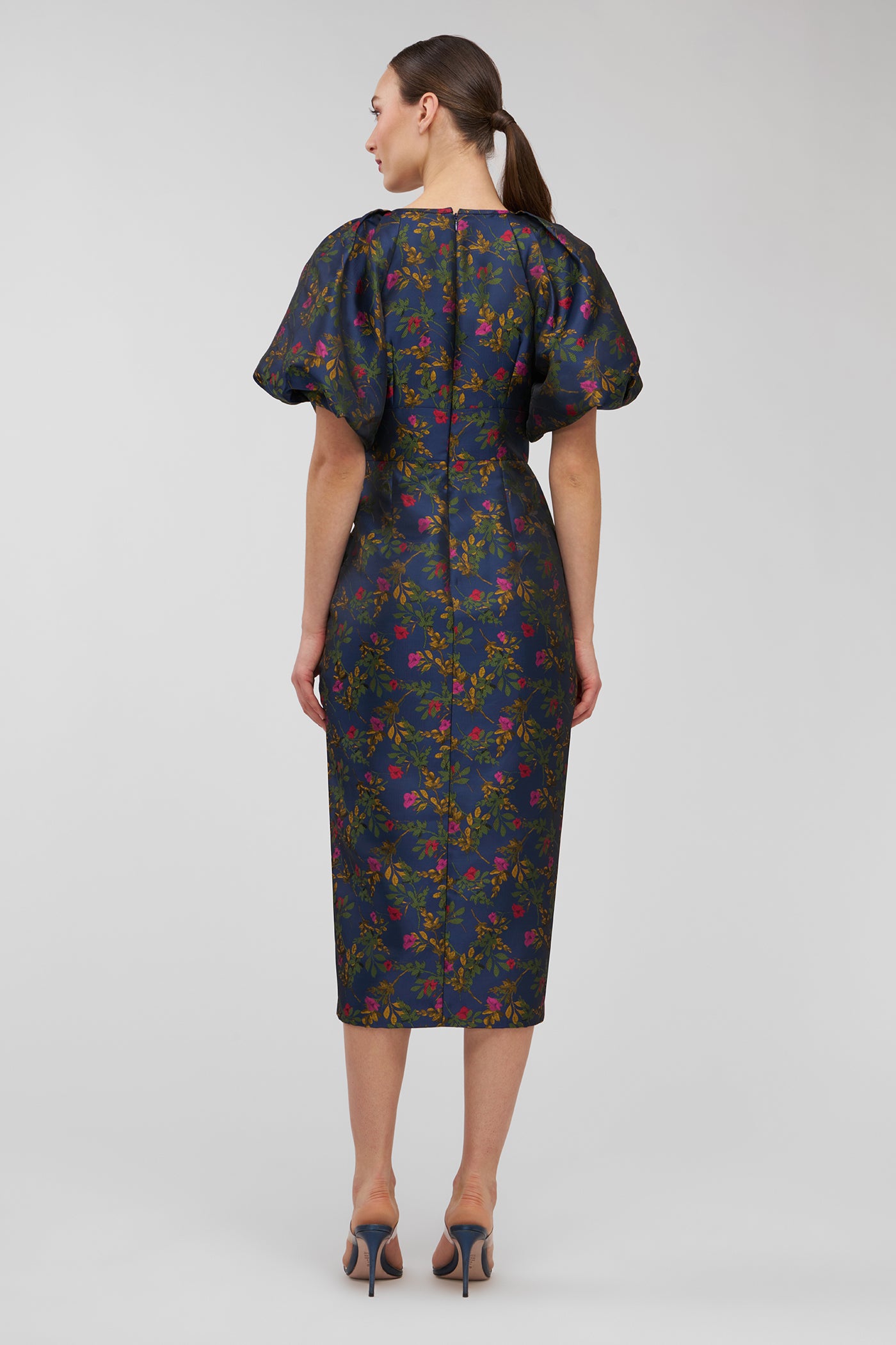 Woman wearing a floral dress on a plain background