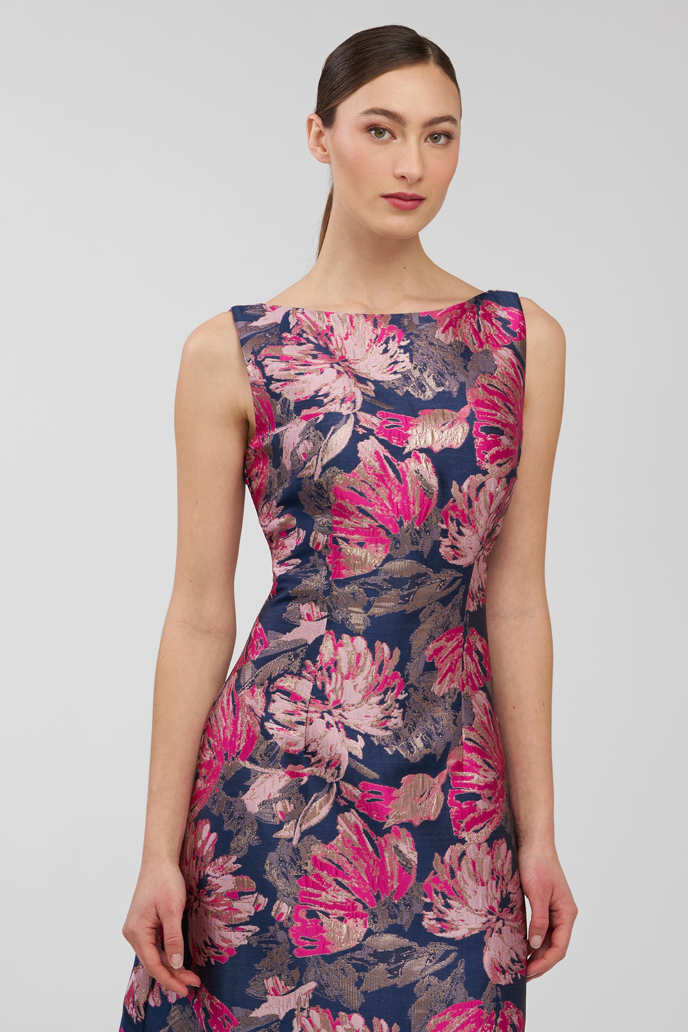 Woman wearing a sleeveless dress with a floral pattern on a plain background