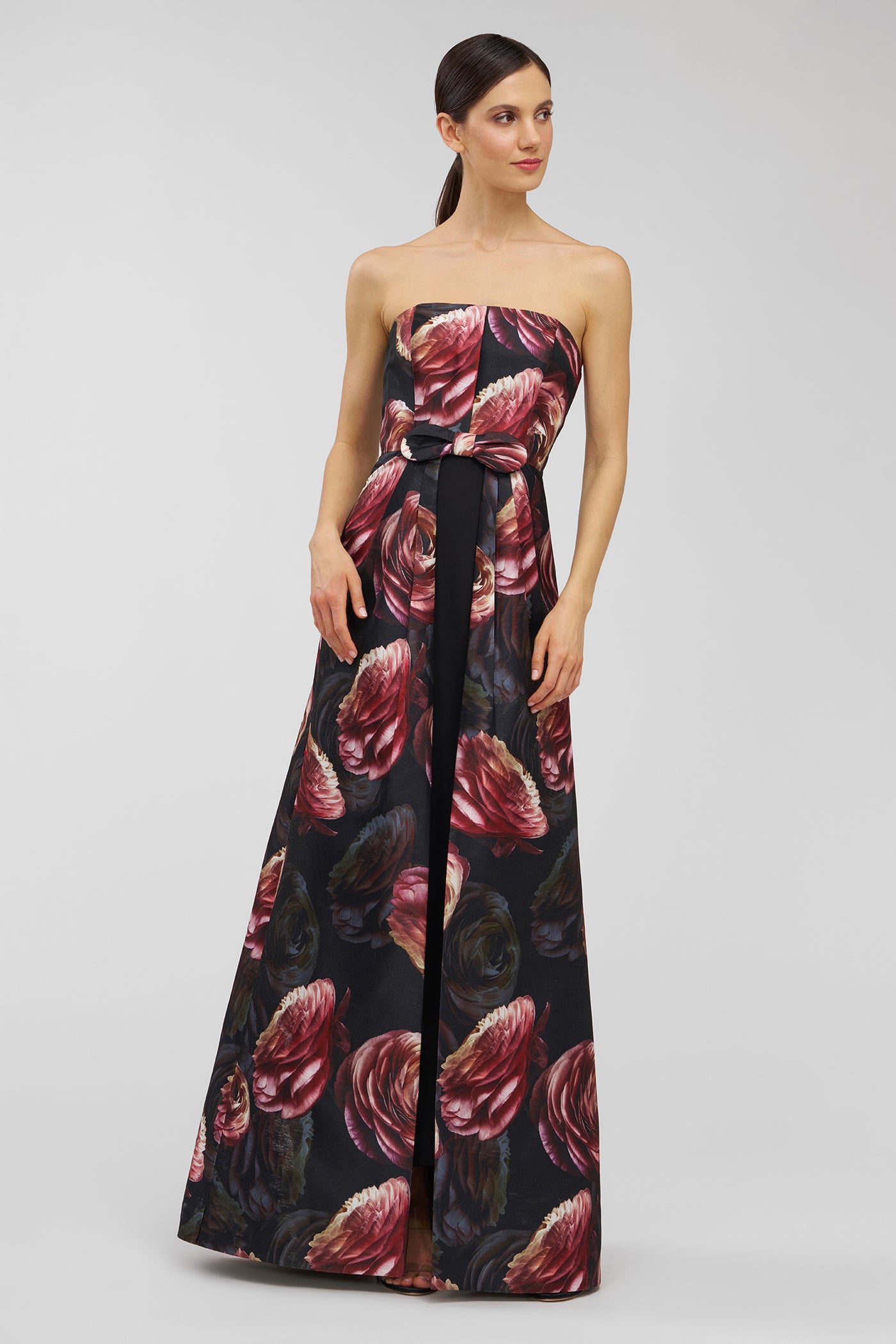 Woman wearing a strapless floral dress on a gray background