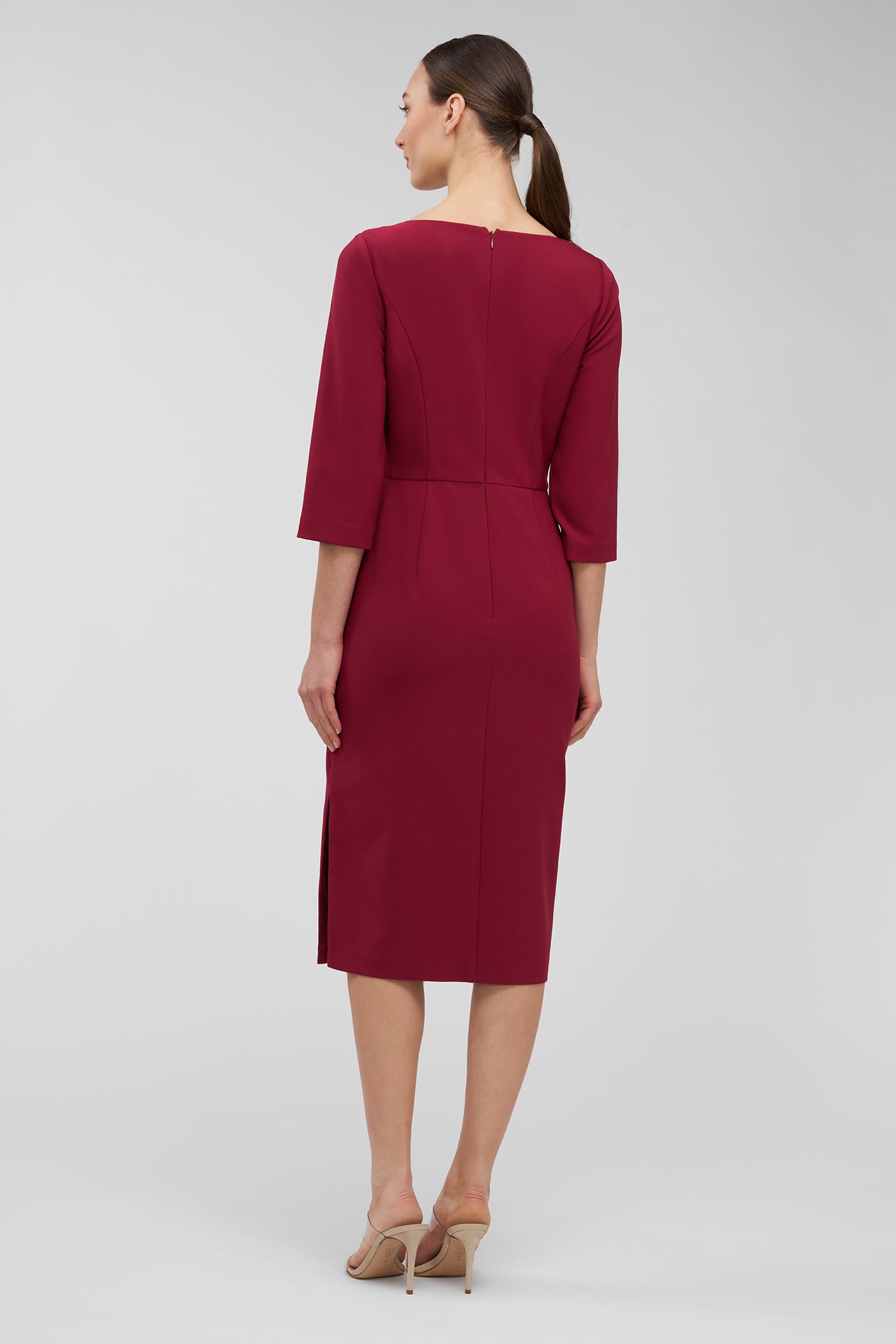 Woman wearing a burgundy dress on a light gray background