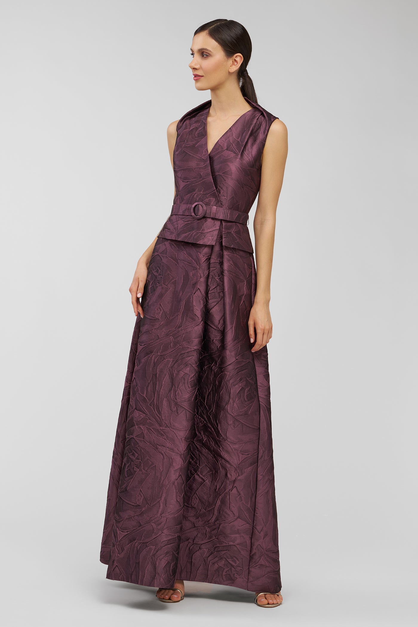 Woman wearing a purple jumpsuit on a light gray background