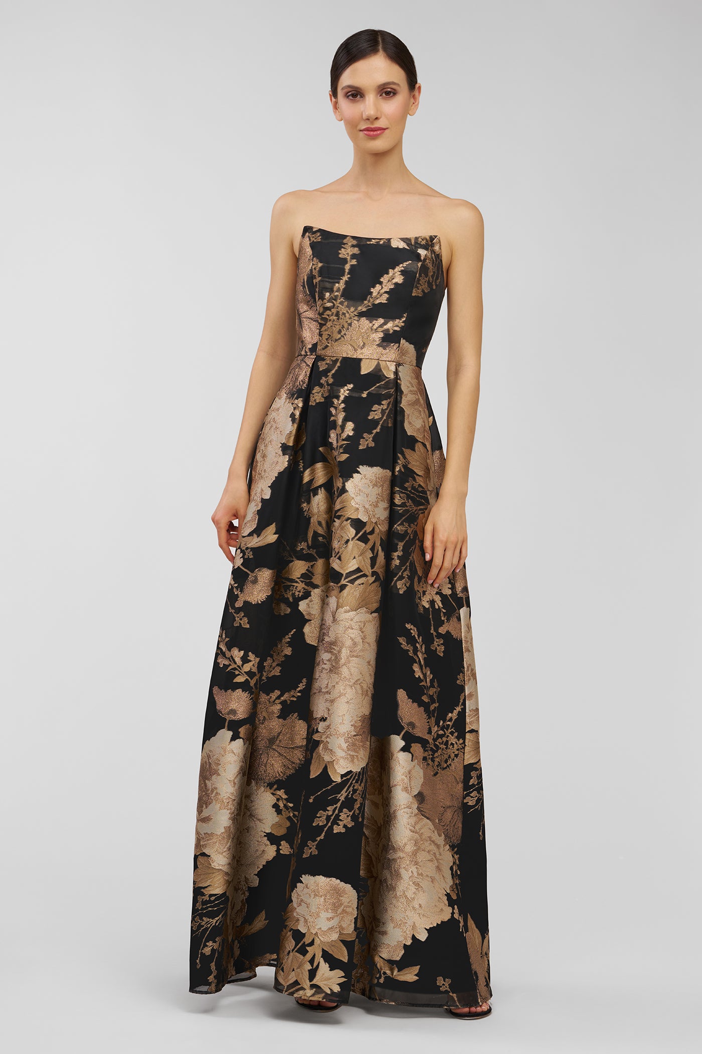 Woman wearing a strapless floral dress on a gray background