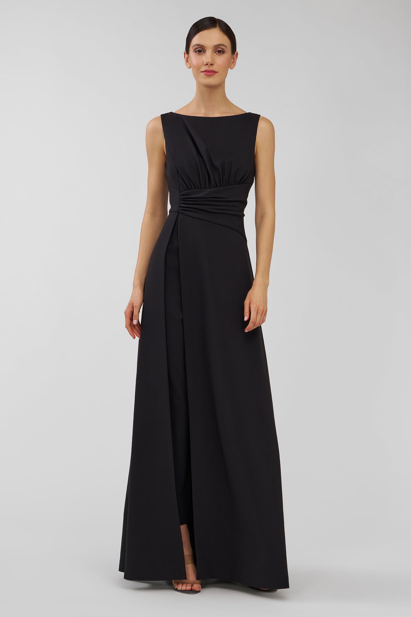 Woman wearing a black evening walk thru jumpsuit on a gray background